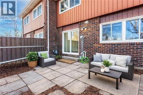 The property features a private patio with paving stones, offering an outdoor living space - 121 University Avenue E Unit# 102, Waterloo, ON - Outdoor