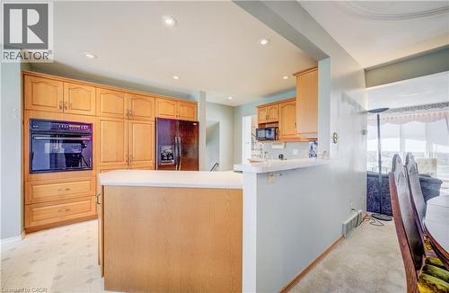 Kitchen with a peninsula, black appliances, light countertops, recessed lighting, and light wood finish cabinets. Open to the dining area. - 564 Glen Manor Boulevard, Waterloo, ON - Indoor Photo Showing Kitchen