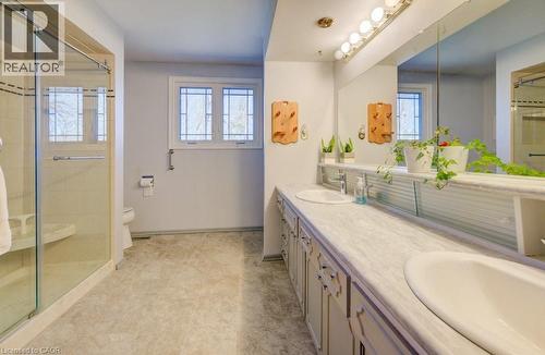 The bathroom features a glass-enclosed shower, dual vanity sinks, and a large mirror with integrated lighting - 564 Glen Manor Boulevard, Waterloo, ON - Indoor Photo Showing Bathroom