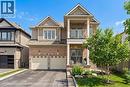 The property features a brick and siding exterior, a two-car garage, and a paved driveway - 4 Macbean Crescent, Waterdown, ON  - Outdoor With Balcony With Facade 