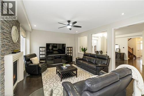 This living area features dark hardwood flooring, recessed lighting, and a ceiling fan - 4 Macbean Crescent, Waterdown, ON - Indoor Photo Showing Living Room