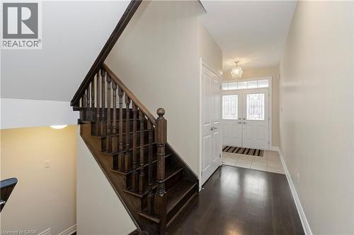 The property features a grand staircase with dark wood newel posts, balusters, and handrails - 4 Macbean Crescent, Waterdown, ON - Indoor Photo Showing Other Room