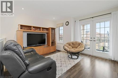 The property features laminate floors, light-colored walls, and a window with white curtains - 4 Macbean Crescent, Waterdown, ON - Indoor Photo Showing Living Room