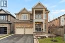 This property features a brick and siding exterior, a two-car garage, and a front porch with a balcony above - 4 Macbean Crescent, Waterdown, ON  - Outdoor With Balcony With Facade 