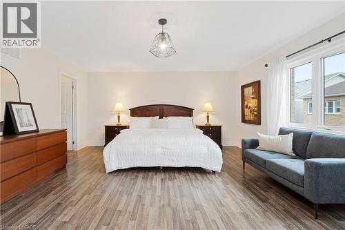 This room features light-colored walls, wood-style flooring, and a contemporary light fixture - 4 Macbean Crescent, Waterdown, ON - Indoor Photo Showing Bedroom