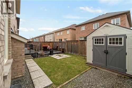 The property features a backyard with a lawn area, a wooden deck, and a storage shed - 4 Macbean Crescent, Waterdown, ON - Outdoor