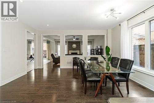 Dining area featuring dark hardwood floors, large windows, and a contemporary light fixture - 4 Macbean Crescent, Waterdown, ON - Indoor Photo Showing Dining Room