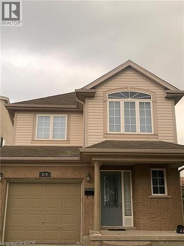 The property features a brick and siding exterior, an integrated garage, and a covered porch entrance - 679 Commonwealth Crescent Unit# Lower, Kitchener, ON - Outdoor With Exterior