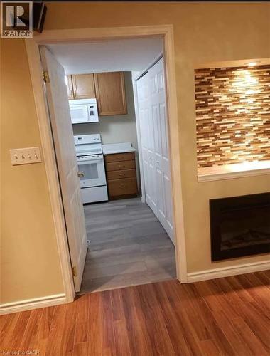 The property features hardwood flooring and an integrated electric fireplace with a decorative tiled surround - 679 Commonwealth Crescent Unit# Lower, Kitchener, ON - Indoor