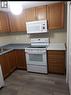 The kitchen features wood cabinetry, a white electric range, and a white microwave - 679 Commonwealth Crescent Unit# Lower, Kitchener, ON  - Indoor Photo Showing Kitchen 