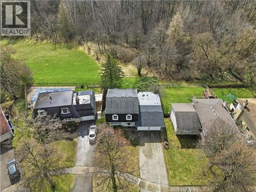 Aerial view of the property and its surroundings, showcasing a large grassy area behind the house and a wooded backdrop - 37 Parkview Crescent, Kitchener, ON - Outdoor With View