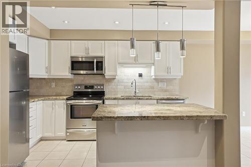 Kitchen with stainless steel appliances, white cabinets, and light stone countertops - 91 Chamomile Drive, Hamilton, ON - Indoor Photo Showing Kitchen With Upgraded Kitchen