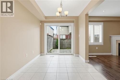 Entryway with tile patterned floors, suspended lighting, and a fireplace - 91 Chamomile Drive, Hamilton, ON - Indoor With Fireplace