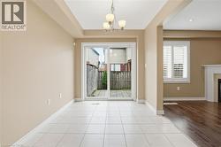 Entryway with tile patterned floors, suspended lighting, and a fireplace - 