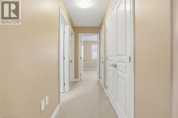 Hallway featuring light carpet and baseboards - 