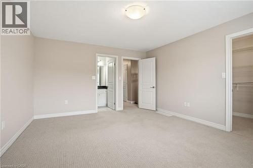 Master bedroom featuring a walk in closet and light colored carpet - 91 Chamomile Drive, Hamilton, ON - Indoor Photo Showing Other Room