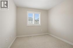 Unfurnished room featuring light colored carpet and baseboards - 