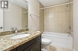 Full bathroom featuring vanity, light tile patterned floors, and  shower combination - 