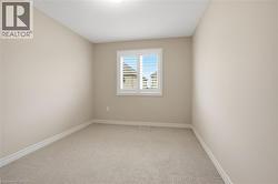 Unfurnished room featuring light colored carpet and baseboards - 