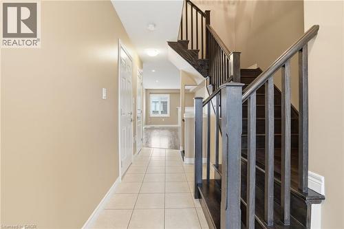 Stairway with baseboards and tile patterned floors - 91 Chamomile Drive, Hamilton, ON - Indoor Photo Showing Other Room