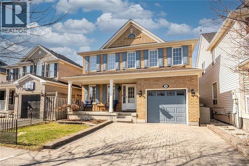 View of front of home with covered porch, decorative driveway, a garage, and brick siding - 599 Caverhill Crescent, Milton, ON - Outdoor With Deck Patio Veranda