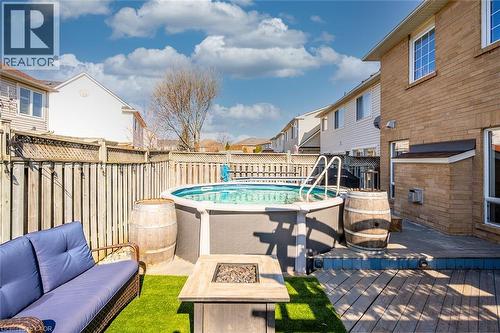 View of pool featuring a fenced backyard, a deck, an outdoor living space with a fire pit, and a residential view - 599 Caverhill Crescent, Milton, ON - Outdoor With Above Ground Pool