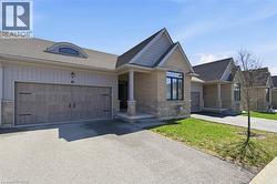 The property features a stone and siding exterior, a two-car garage with a textured finish, and a dormer window above the garage - 