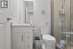 The bathroom features a modern vanity with a rectangular sink, a wall-mounted mirror, and a toilet - 