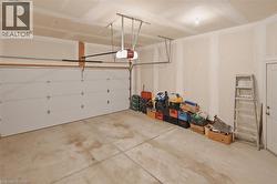 The property features an attached garage with a white garage door, a garage door opener, and concrete flooring - 