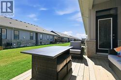 The property features a spacious backyard with a well-maintained lawn and a wooden deck - 