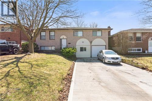 Bi-level home with driveway, a front yard, brick siding, and an attached garage - 23 Amherst Drive, Kitchener, ON - Outdoor With Facade