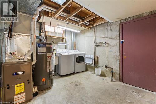 Unfinished below grade area featuring gas water heater, heating unit, and washer and clothes dryer - 23 Amherst Drive, Kitchener, ON - Indoor Photo Showing Laundry Room