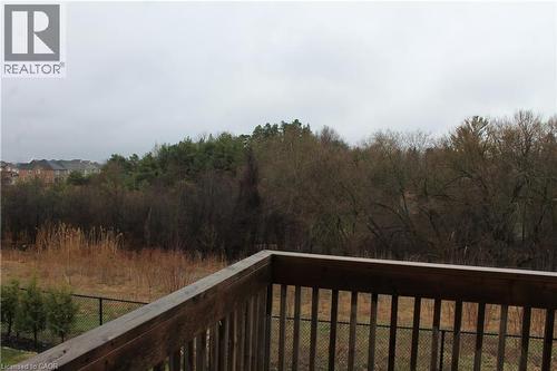 Outdoor deck with wood railings overlooking a natural landscape featuring mature trees and varied foliage - 40 Compass Trail, Cambridge, ON - Outdoor With View