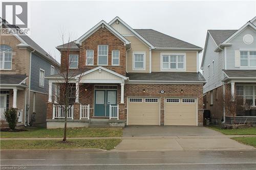 The property features a brick and siding exterior with a covered porch and dual front doors - 40 Compass Trail, Cambridge, ON - Outdoor With Facade
