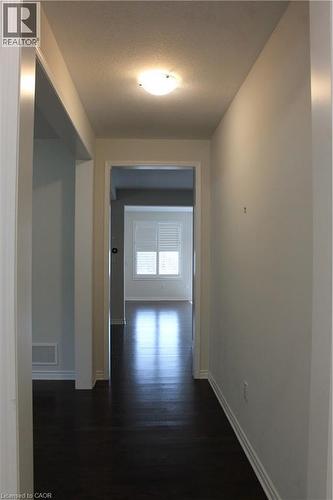 Hallway featuring dark wood-finish flooring, white baseboards, and a flush-mount ceiling light fixture - 40 Compass Trail, Cambridge, ON - Indoor Photo Showing Other Room