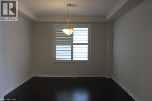 Interior room with dark wood-finish flooring, white baseboards, and neutral wall paint - 40 Compass Trail, Cambridge, ON - Indoor Photo Showing Other Room
