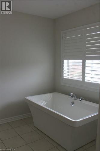 Freestanding white soaking tub with polished chrome fixtures - 40 Compass Trail, Cambridge, ON - Indoor Photo Showing Bathroom