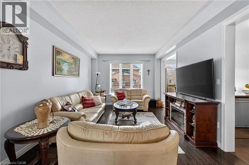 Living area featuring hardwood flooring, light-colored walls, and a window providing natural light - 44 Matteo Trail, Hamilton, ON - Indoor Photo Showing Living Room