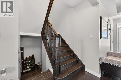 The property features a staircase with dark wood treads and a matching banister, complemented by light-colored walls - 44 Matteo Trail, Hamilton, ON - Indoor Photo Showing Other Room