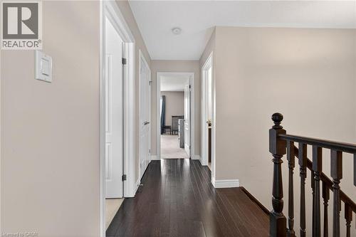 This hallway features dark hardwood floors and light-colored walls - 44 Matteo Trail, Hamilton, ON - Indoor Photo Showing Other Room