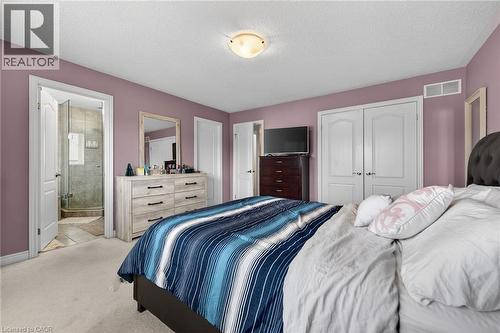 This room features light purple walls, a light-colored carpet, and a white ceiling with a flush-mount light fixture - 44 Matteo Trail, Hamilton, ON - Indoor Photo Showing Bedroom
