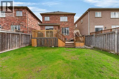 The property features a private backyard with a well-maintained lawn, a wooden fence, and a wooden deck - 44 Matteo Trail, Hamilton, ON - Outdoor With Deck Patio Veranda With Exterior