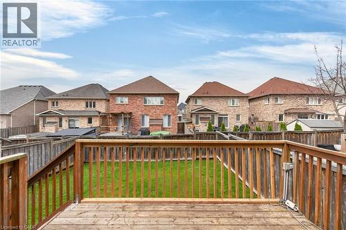 The property features a spacious wooden deck overlooking a fenced backyard with a well-maintained lawn - 44 Matteo Trail, Hamilton, ON - Outdoor With Deck Patio Veranda