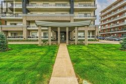 The property features a well-maintained lawn and a concrete pathway leading to the main entrance - 
