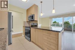 The kitchen features cabinetry with modern hardware, stainless steel appliances, and granite countertops - 