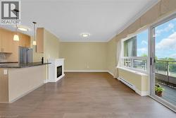 Bright living area featuring hardwood flooring, a fireplace, and a sliding glass door opening to an outdoor space - 