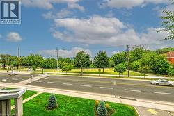 The property offers views of a clear blue sky with clouds, a verdant landscape with mature trees, and a road - 