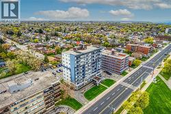 This property offers a residential high-rise building with balconies, surrounded by green spaces and a paved road - 