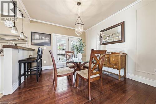 This dining area features hardwood flooring, a ceiling-mounted light fixture, and crown molding - 30 Grand Avenue, Caledonia, ON - Indoor Photo Showing Dining Room