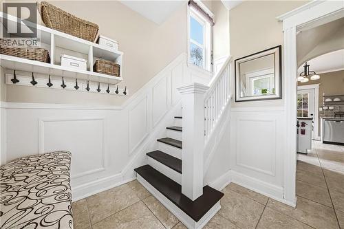 The entryway features wainscoting, a staircase with dark treads, and tiled flooring - 30 Grand Avenue, Caledonia, ON 